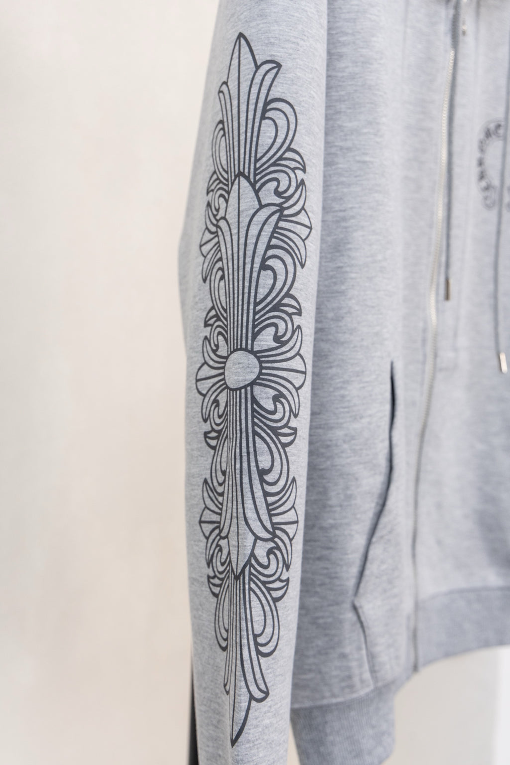 Heather gray zip-up hoodie sleeve with ornamental graphic