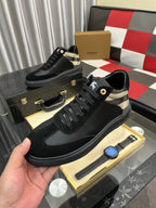 Black low-top sneakers with check-panel accents, lace-up uppers, and padded collars