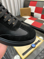 Close-up of black low-top sneaker with textured suede toe and lace panel
