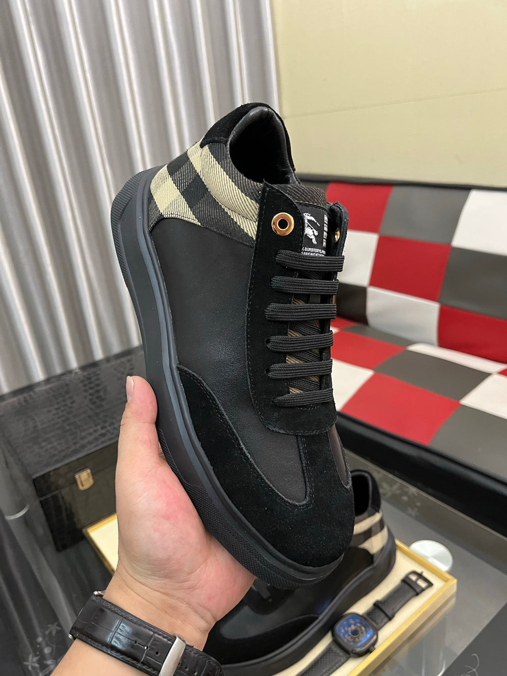 Black low-top sneaker with beige-and-black check collar and lace-up closure