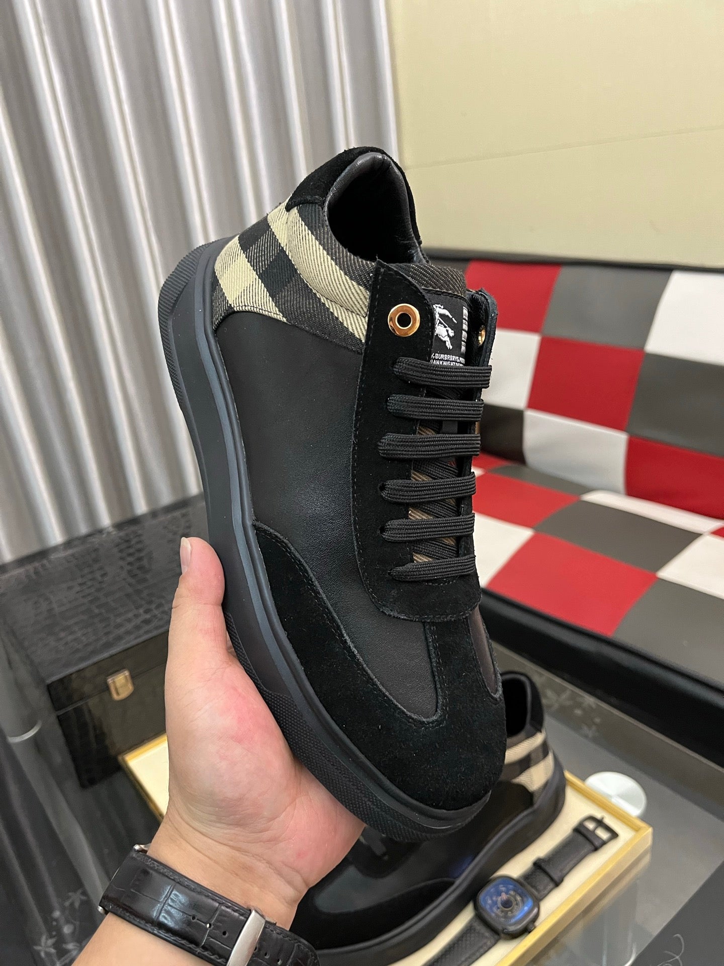 Black low-top sneaker with beige-and-black check collar and lace-up closure