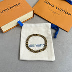 Gold-tone chain bracelet on white fabric pouch with blue drawstring