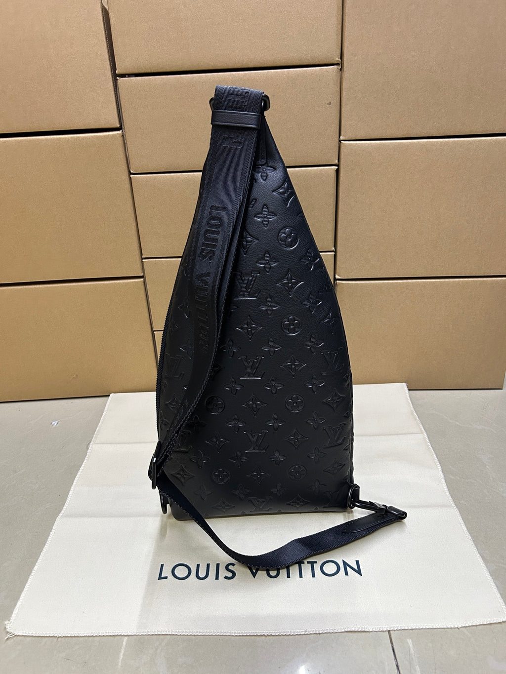 Men's Louis Vuitton monogram leather sling bag, dark blue/black, side view with strap