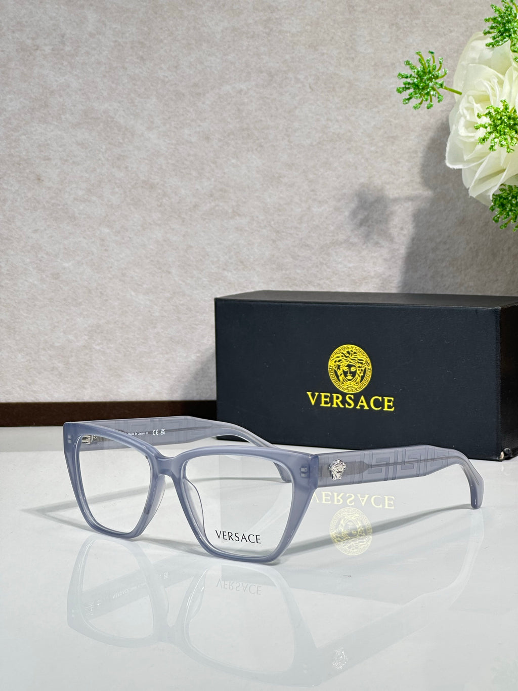 Light blue rectangular eyeglasses with clear lenses and VERSACE logo on temple arms
