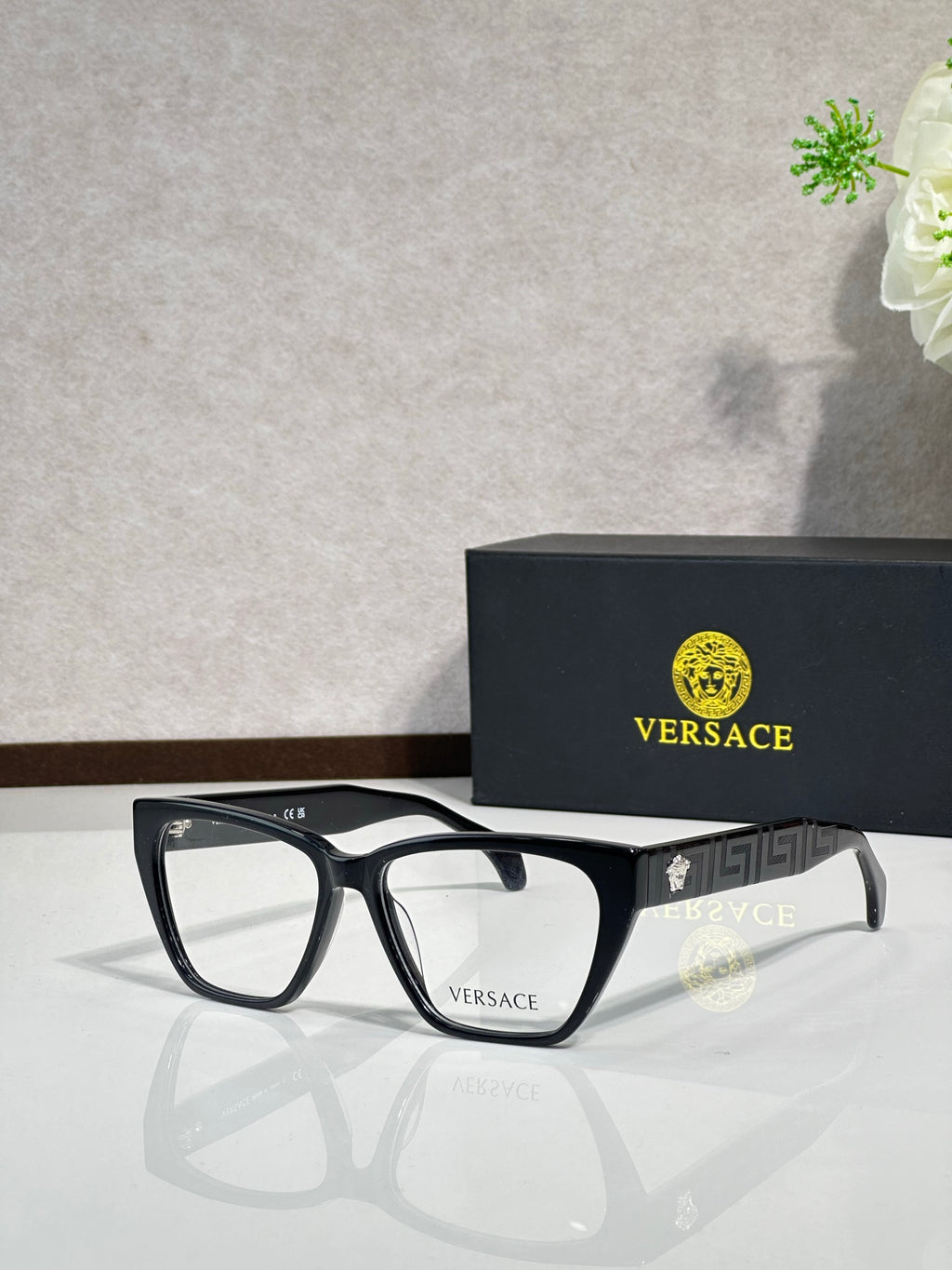 Black rectangular eyeglasses with clear lenses and VERSACE logo on temple arms