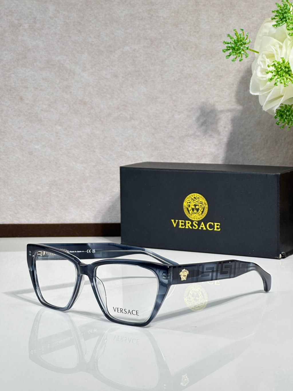 Blue rectangular eyeglasses with clear lenses and VERSACE logo on temple arms