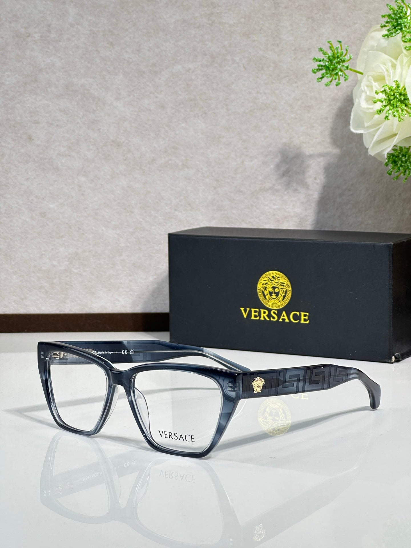 Blue rectangular eyeglasses with clear lenses and VERSACE logo on temple arms