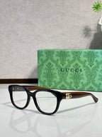 Gucci eyeglasses with black frames, gold bridge accent and logo temple detail