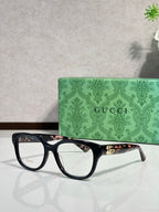 Gucci eyeglasses with black frames and gold logo hinge detail