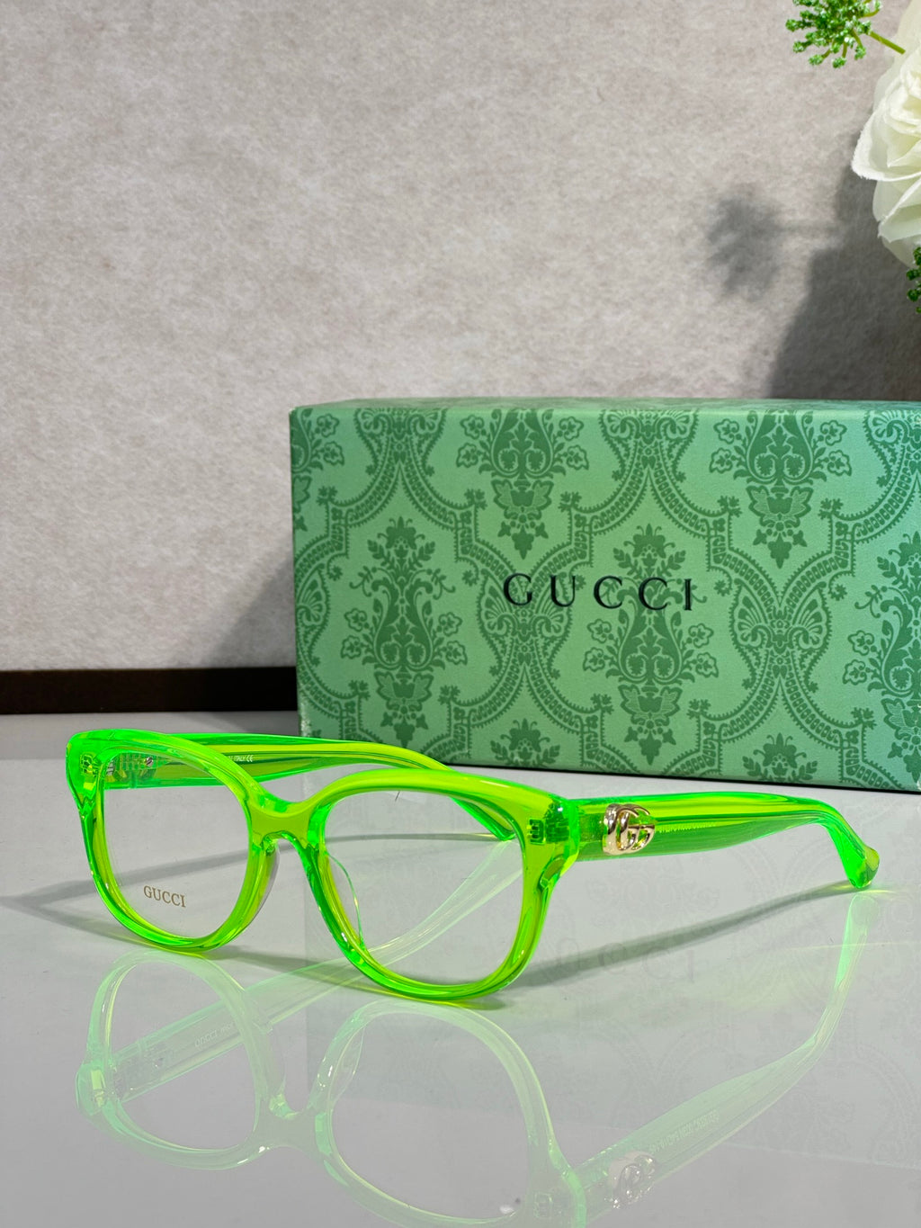 Gucci eyeglasses with neon green frames and gold logo hinge detail
