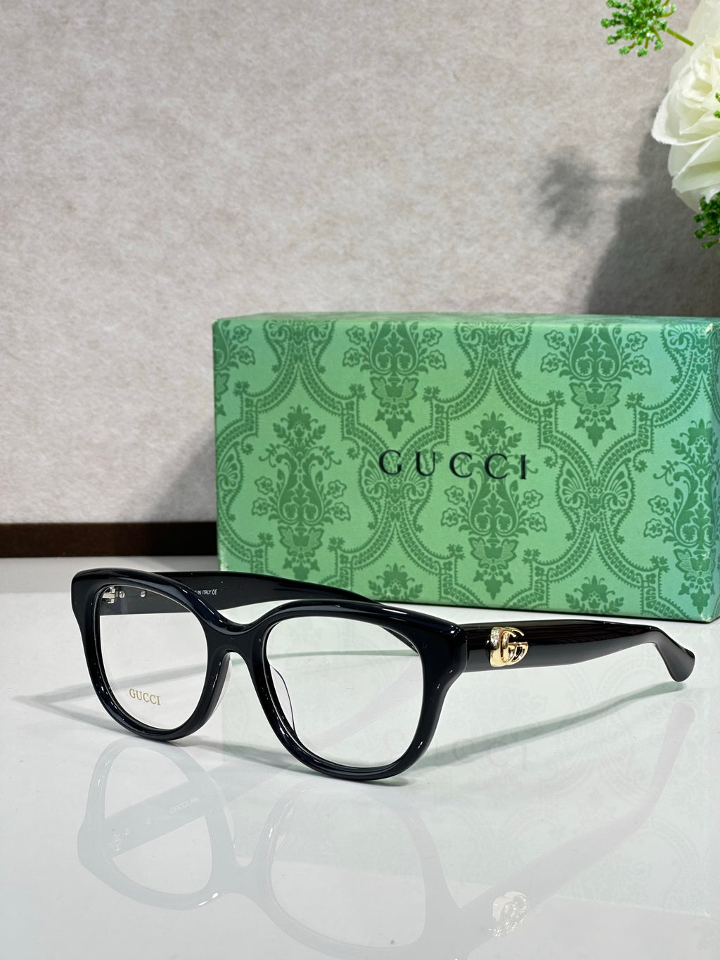Gucci eyeglasses with dark black frames and gold logo temple detail