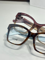 Burgundy and amber eyeglass frames with clear lenses, gold-tone hinge detail