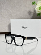 Black squared eyeglass frames with clear lenses and gold-tone logo at temple