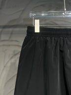 Black pants with gathered elastic waistband and draped front folds