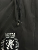 Black pants with front zipper and embroidered lion crest patch