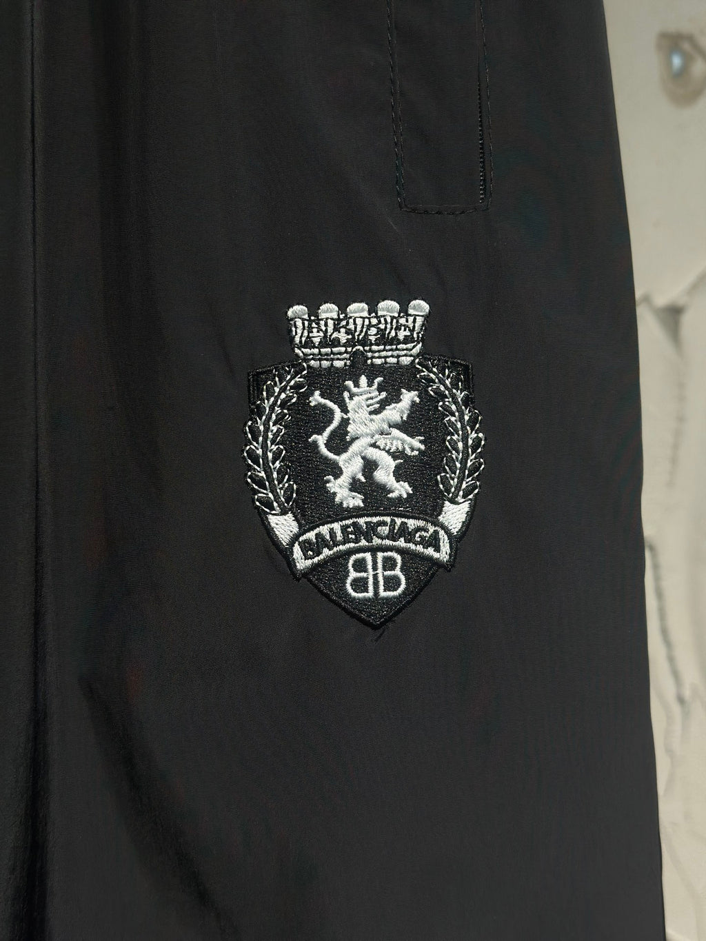 Black pants with crest emblem and “BALENCIAGA” text embroidery
