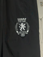 Black pants with crest emblem and “BALENCIAGA” text embroidery