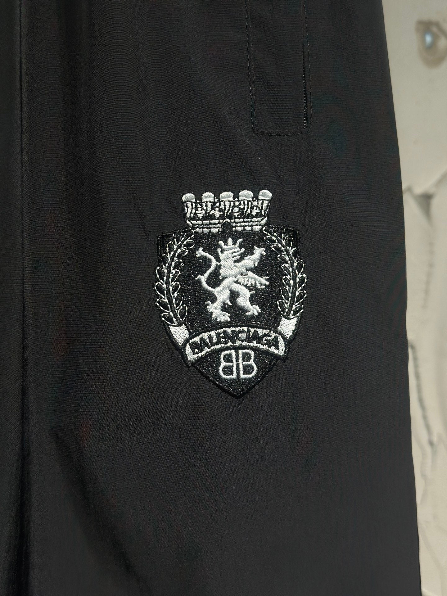 Black pants with crest emblem and “BALENCIAGA” text embroidery