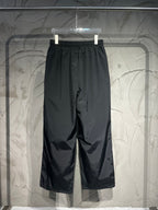 Black wide-leg Balenciaga pants with elastic waistband and side embroidered logos