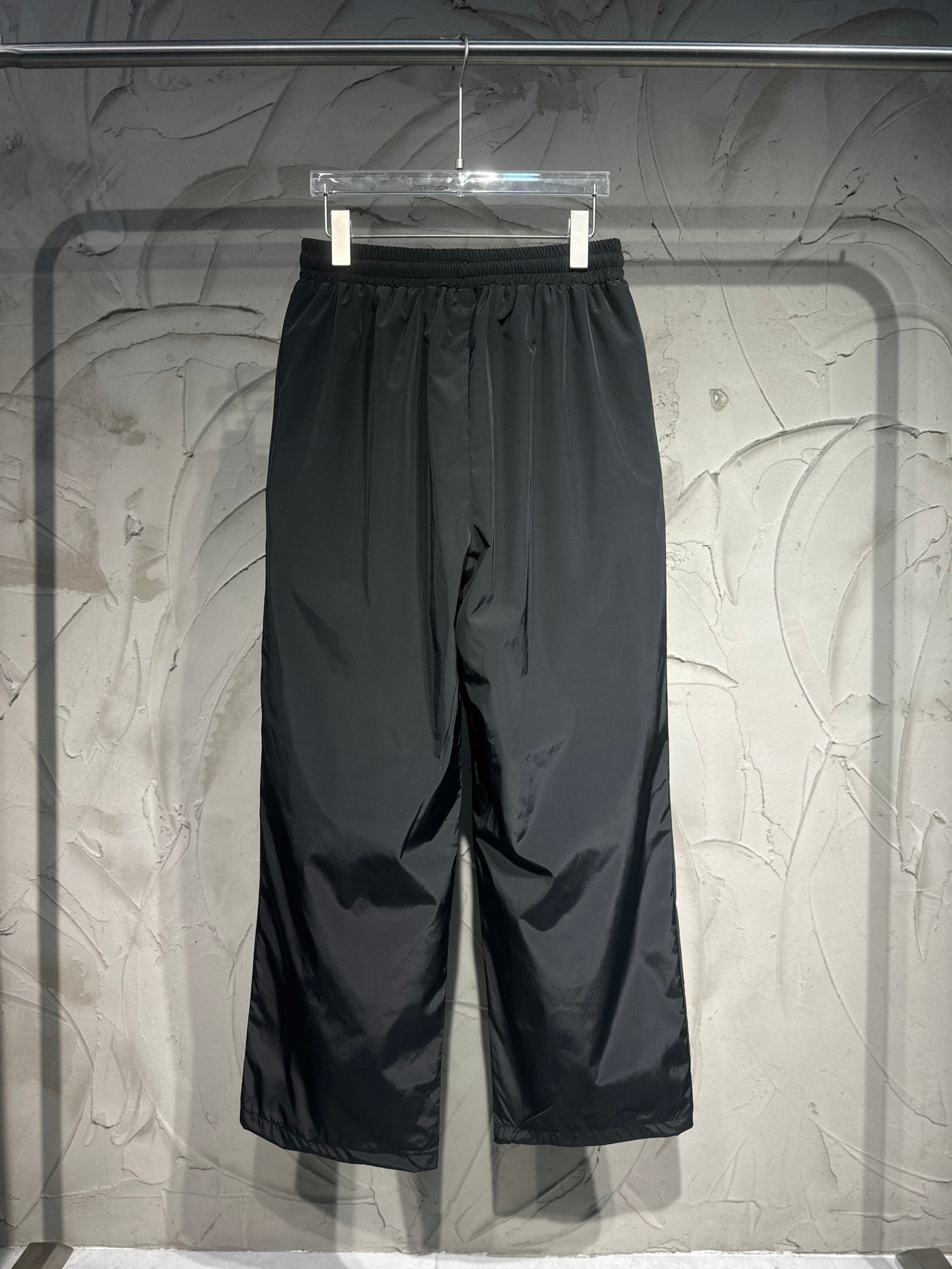 Black wide-leg Balenciaga pants with elastic waistband and side embroidered logos