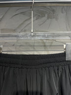 Black pants with ribbed elastic waistband and gathered front detail