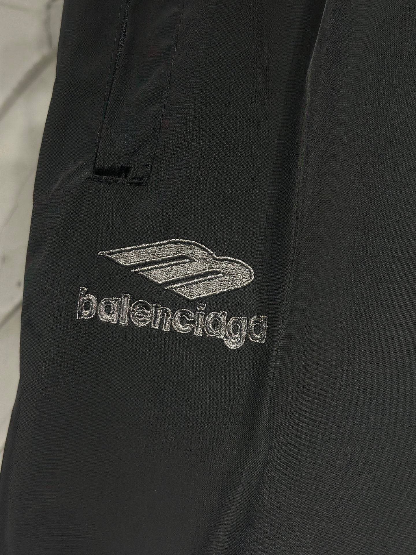 Black pants with “balenciaga” logo and sail-like graphic embroidery