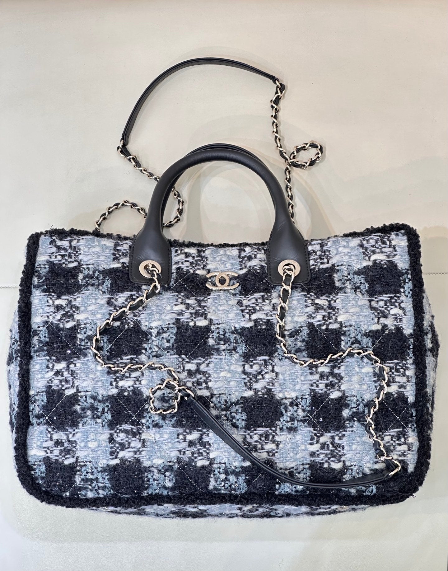 Chanel tote bag in blue and black tweed with black leather handles and chain strap