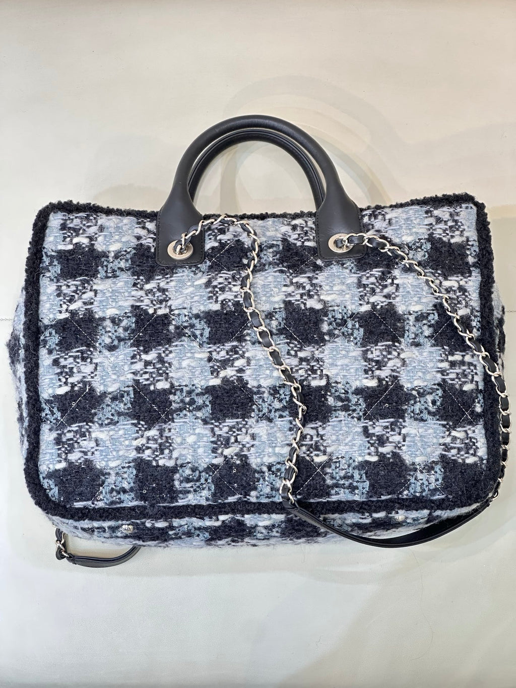 Chanel tote bag front view in blue and black tweed with chain strap and black handles