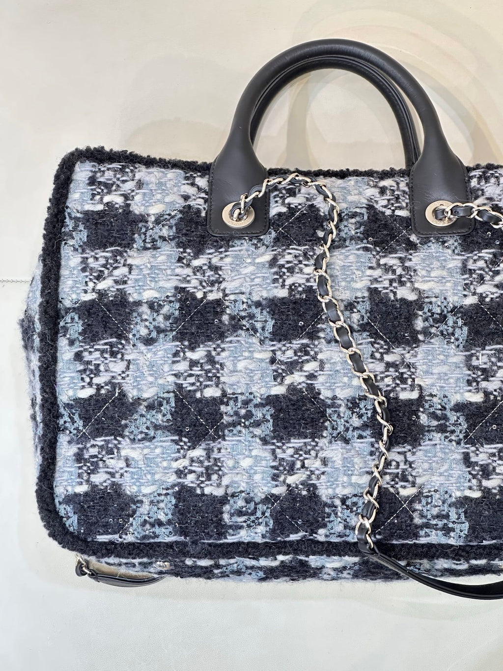 Chanel tote bag front angle showing blue/black tweed texture and gold logo detail