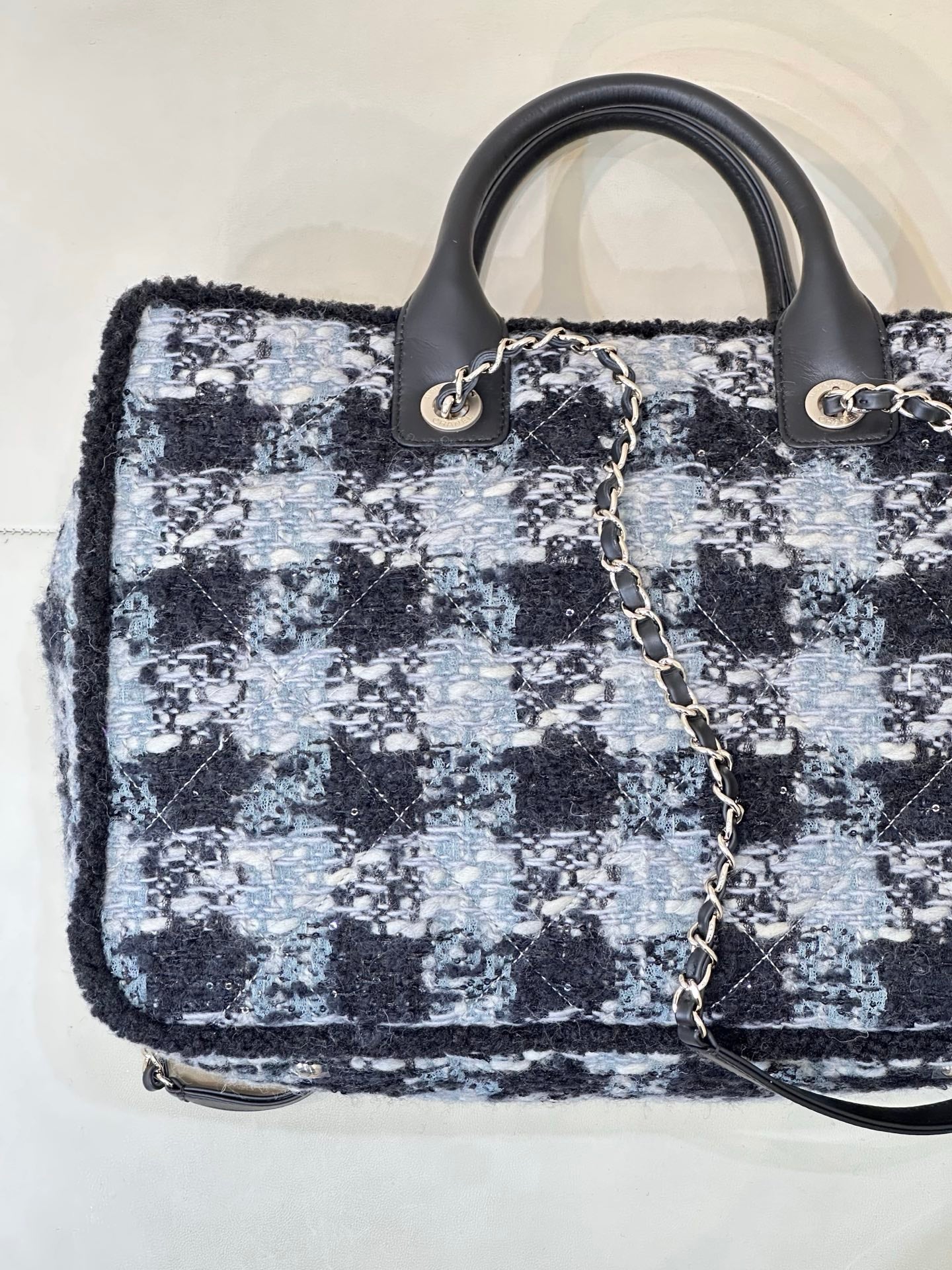 Chanel tote bag front angle showing blue/black tweed texture and gold logo detail