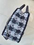 Chanel tote bag side view in blue/black tweed with black leather base and chain strap