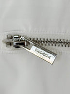 Silver metal zipper on white T-shirt with Prada Milano engraving