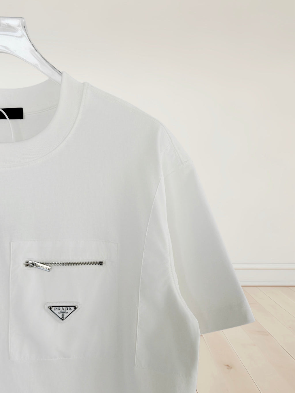 White short-sleeve T-shirt with chest logo patch and metal zipper detail