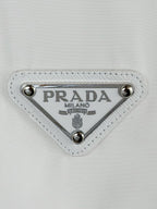 Triangular Prada Milano logo patch with silver studs on white T-shirt