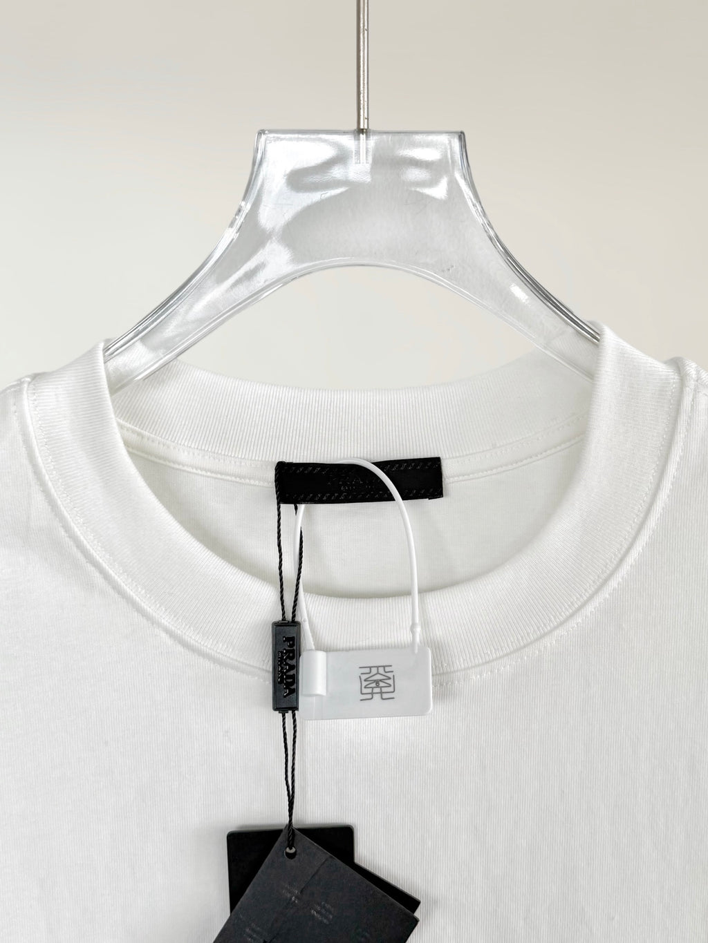 White crewneck T-shirt collar with black inner label and hanging tag
