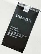 Black care label on white T-shirt fabric with Prada Milano details