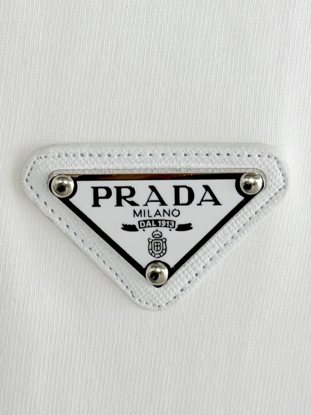 Prada Milano logo patch on white fabric with silver studs