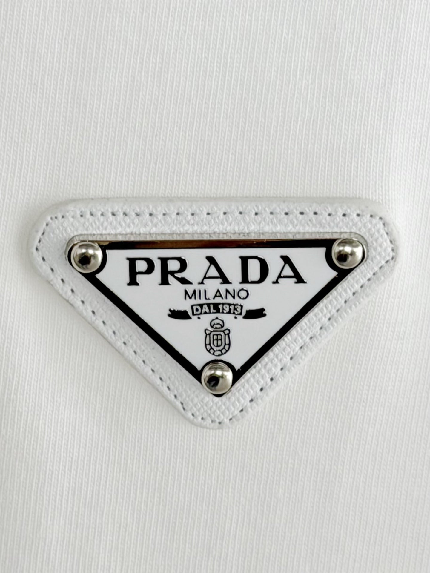 Prada Milano logo patch on white fabric with silver studs