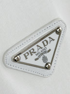Prada Milano logo patch detail on white fabric with silver studs