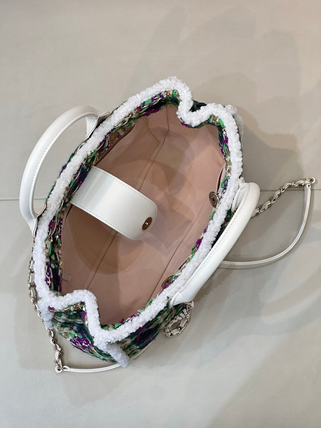 Chanel tweed handbag interior view, white trim with visible lining and top handle openings