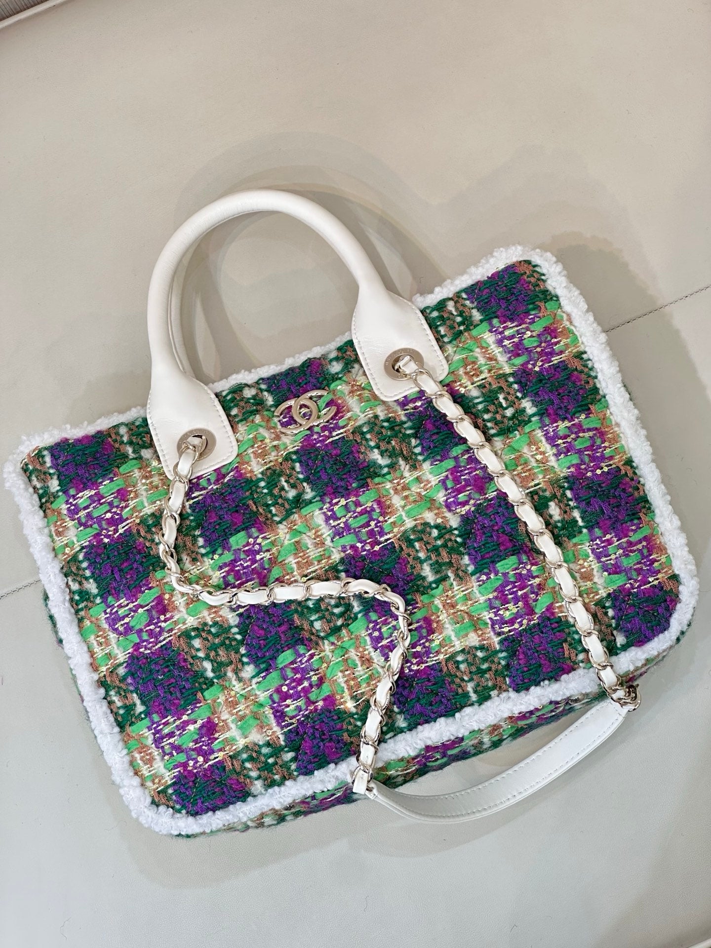 Chanel tweed handbag viewed from above, white handles, multicolor woven fabric, chain strap
