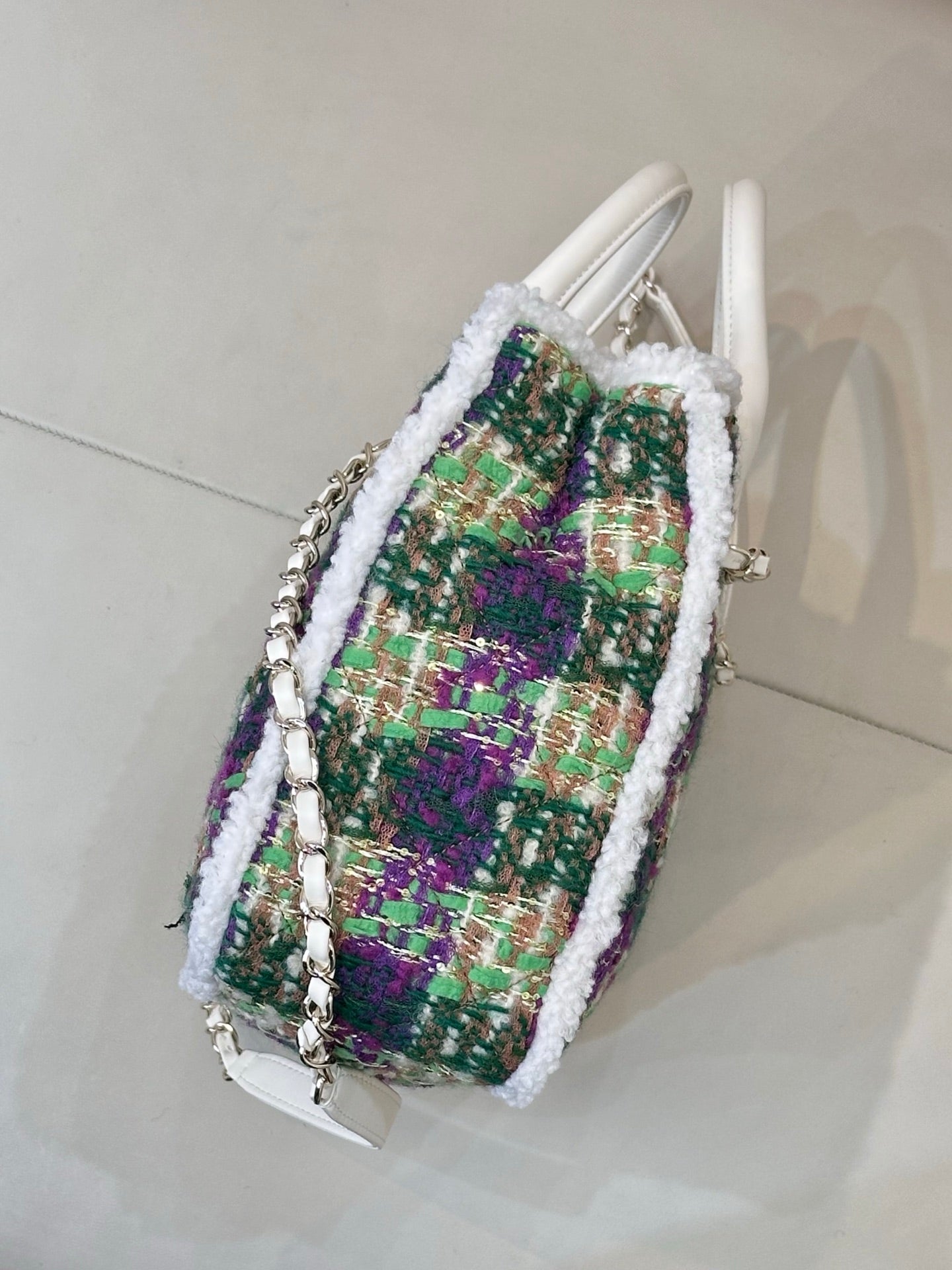 Chanel tweed handbag angled view, white handles, multicolor fabric with white fringe trim