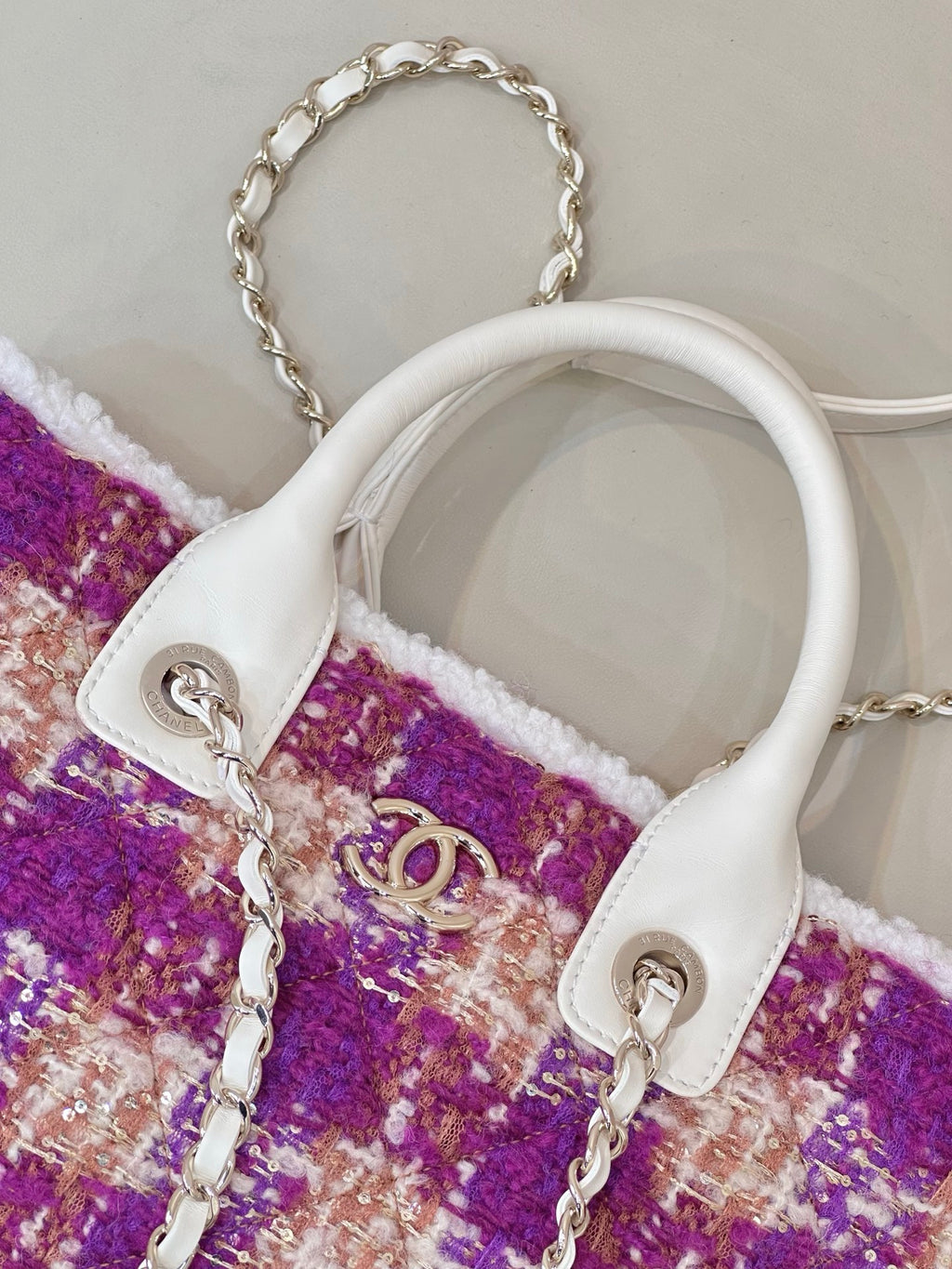 Chanel bag detail: white leather top handles, silver chain, purple tweed front panel