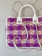 Chanel bag showing logo emblem on white tabs, purple tweed with silver chain