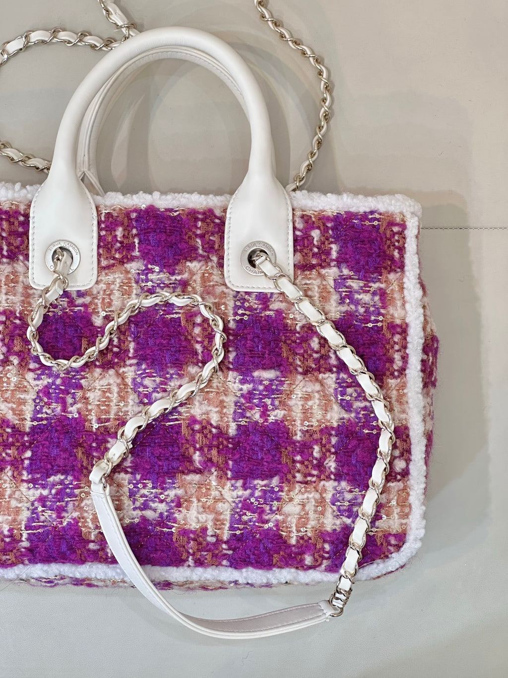Chanel bag close-up of white handle mounts and silver chain on purple tweed