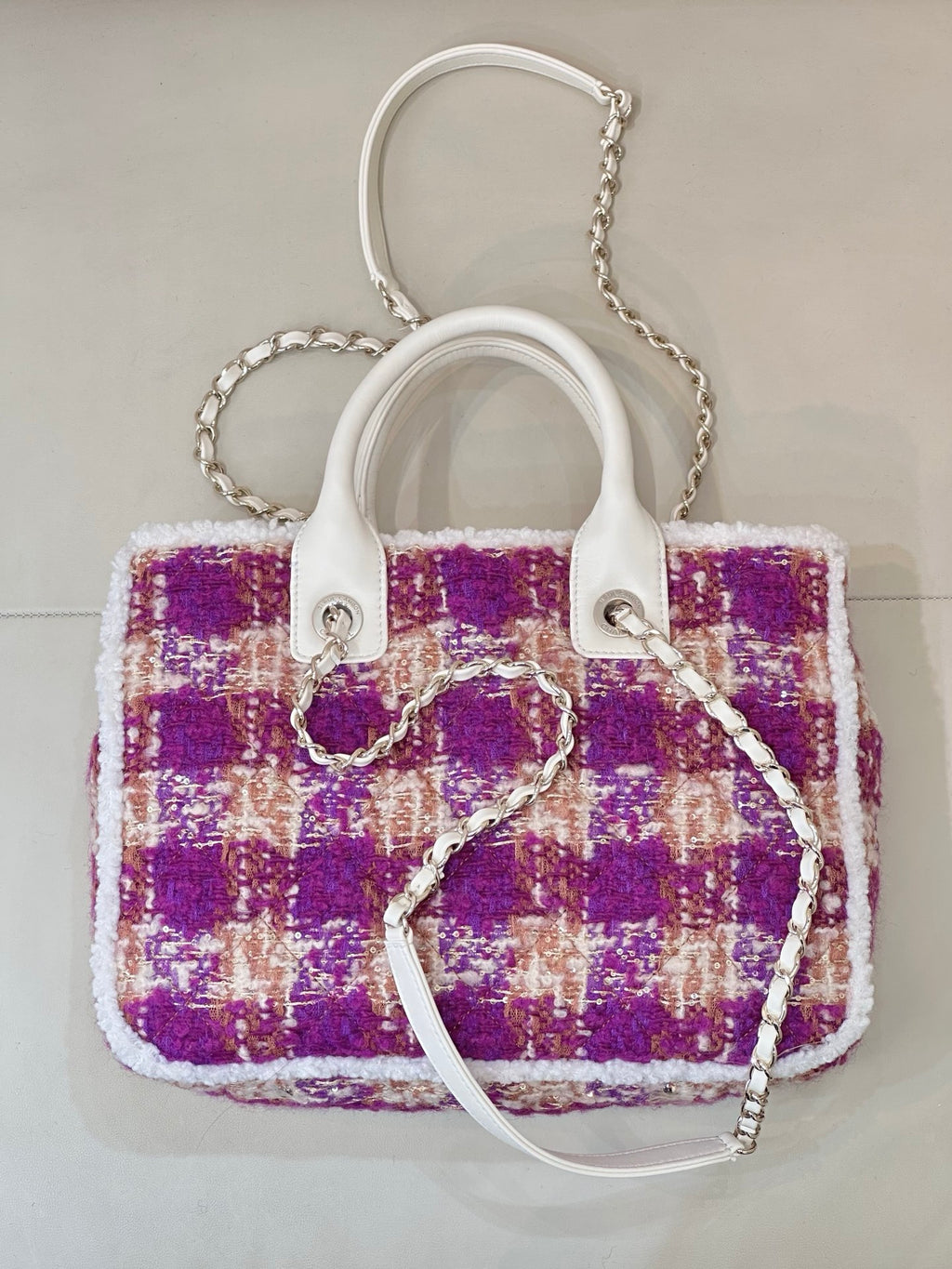 Chanel tote-style bag in purple and cream tweed with white handles and chain strap