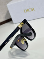 Dior sunglasses close-up of black frame and purple tinted lens, gold hinge