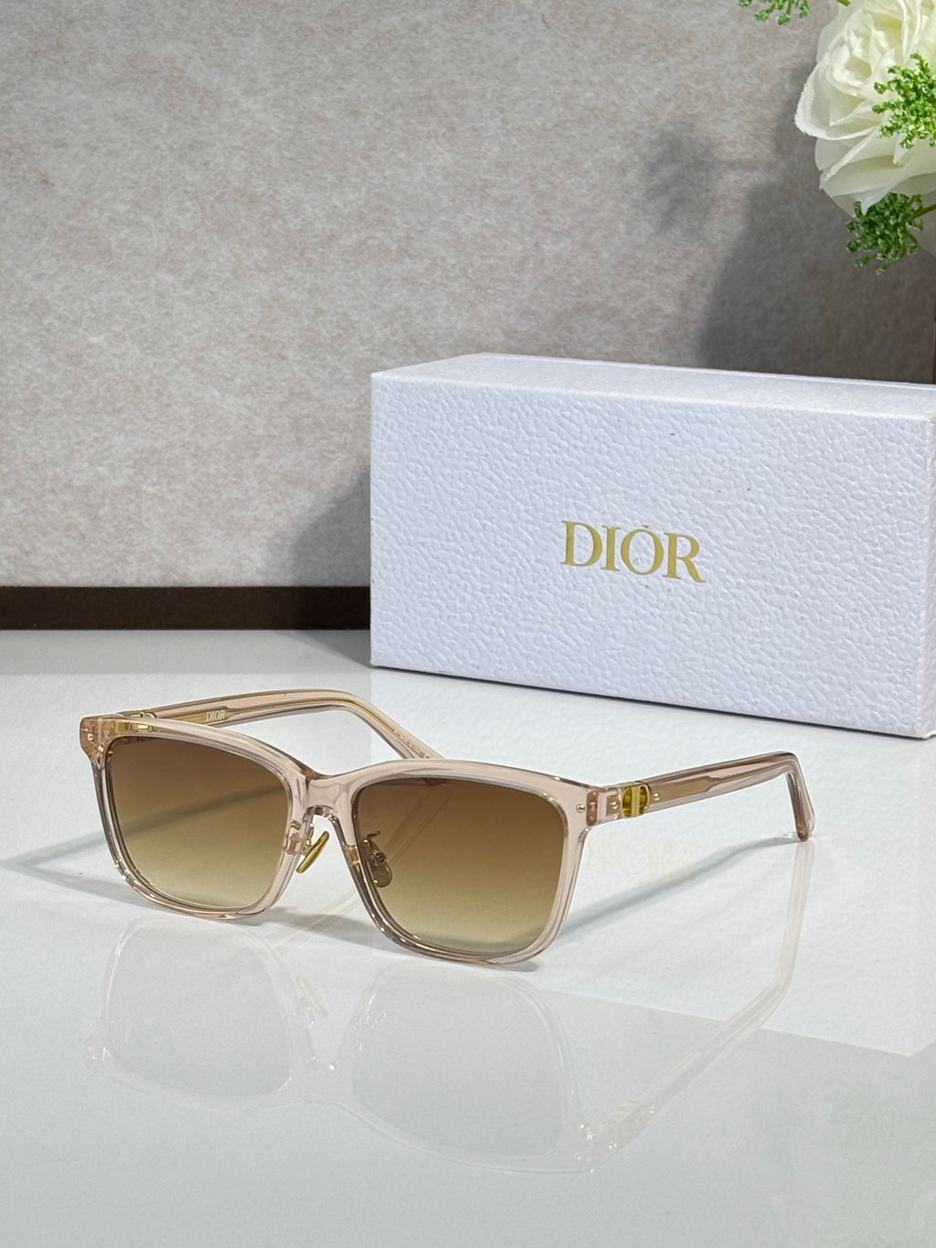 Dior sunglasses with beige translucent frames and tan tinted lenses, gold accents