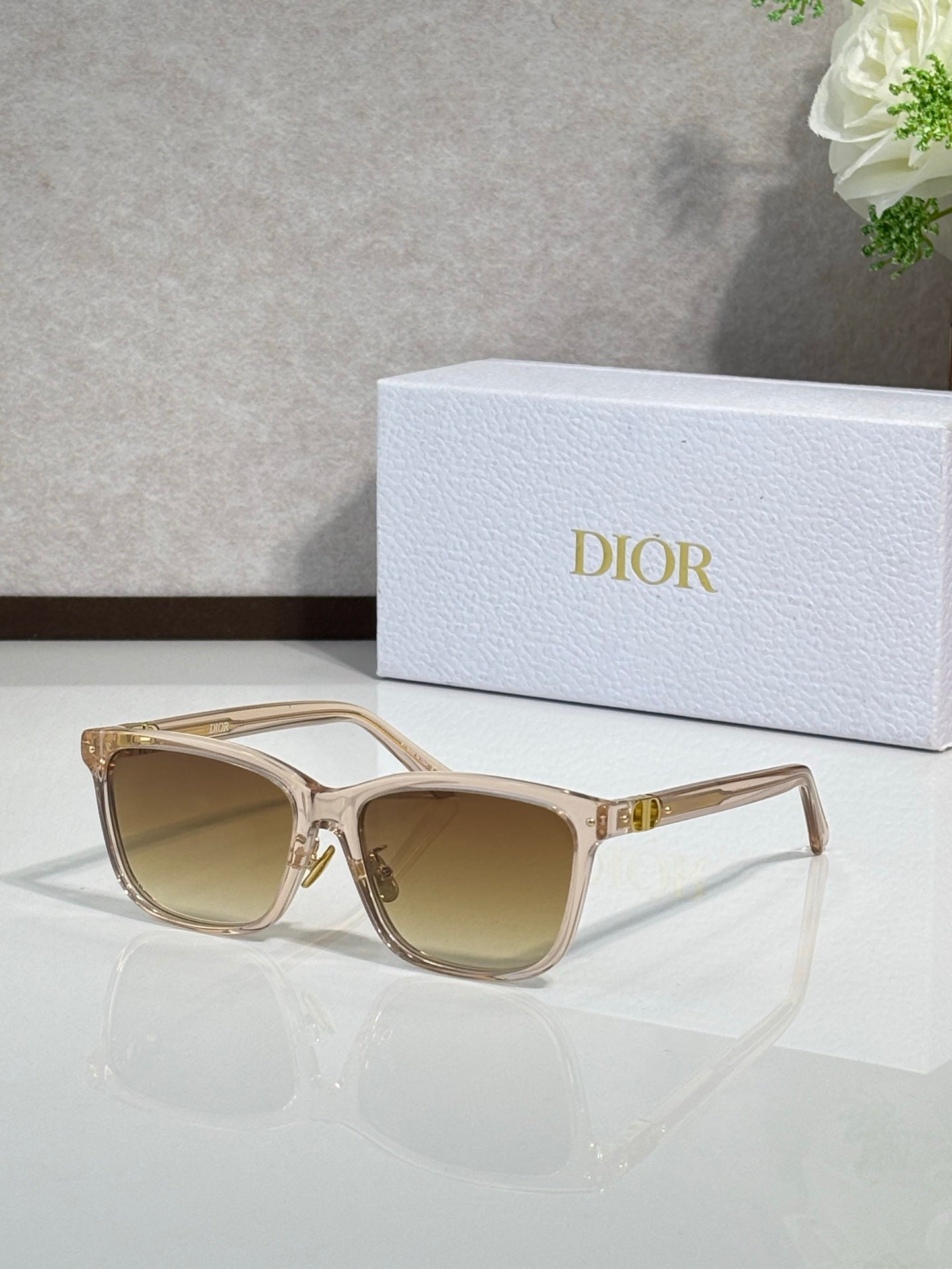Dior sunglasses with beige translucent frames and tan tinted lenses, gold accents