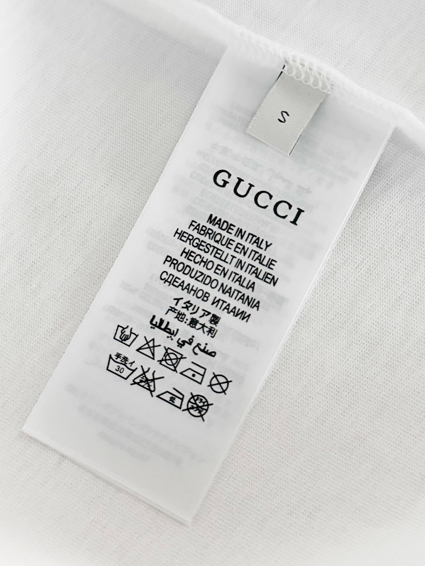 White T-shirt care label with size and Made in Italy information